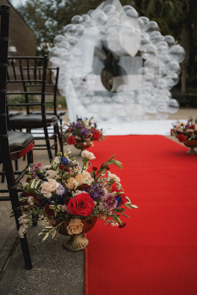vintage 1970s wedding ceremony decor florals red carpet and bubble arch