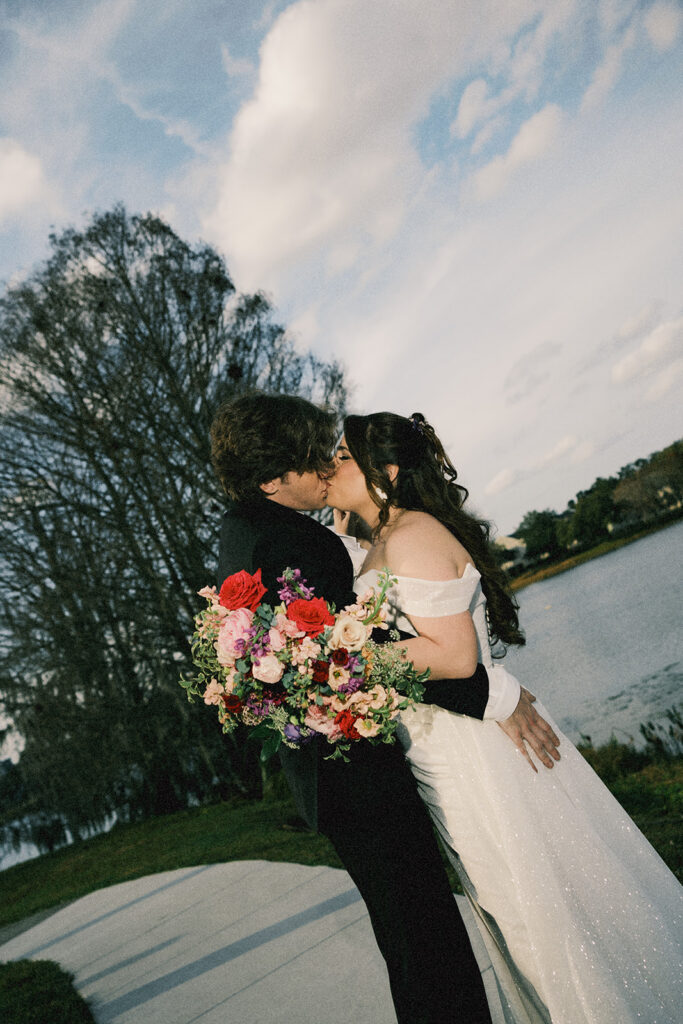 bride and groom kiss by the lake in downtown Orlando