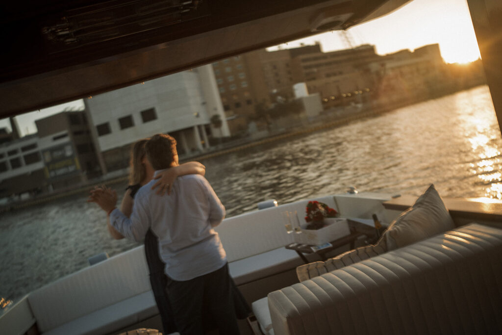 Couple celebrating on the boat after their surprise proposal, photographed by a surprise proposal photographer
